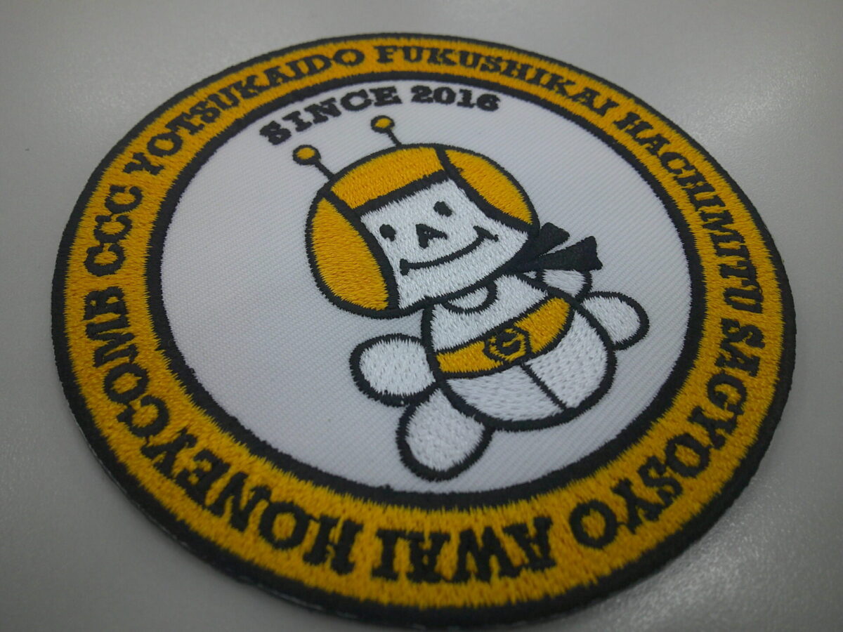 よつかいどう福祉会の刺繍ワッペン。クラシックな雰囲気と刺繍の風合いが非常にマッチした作品。