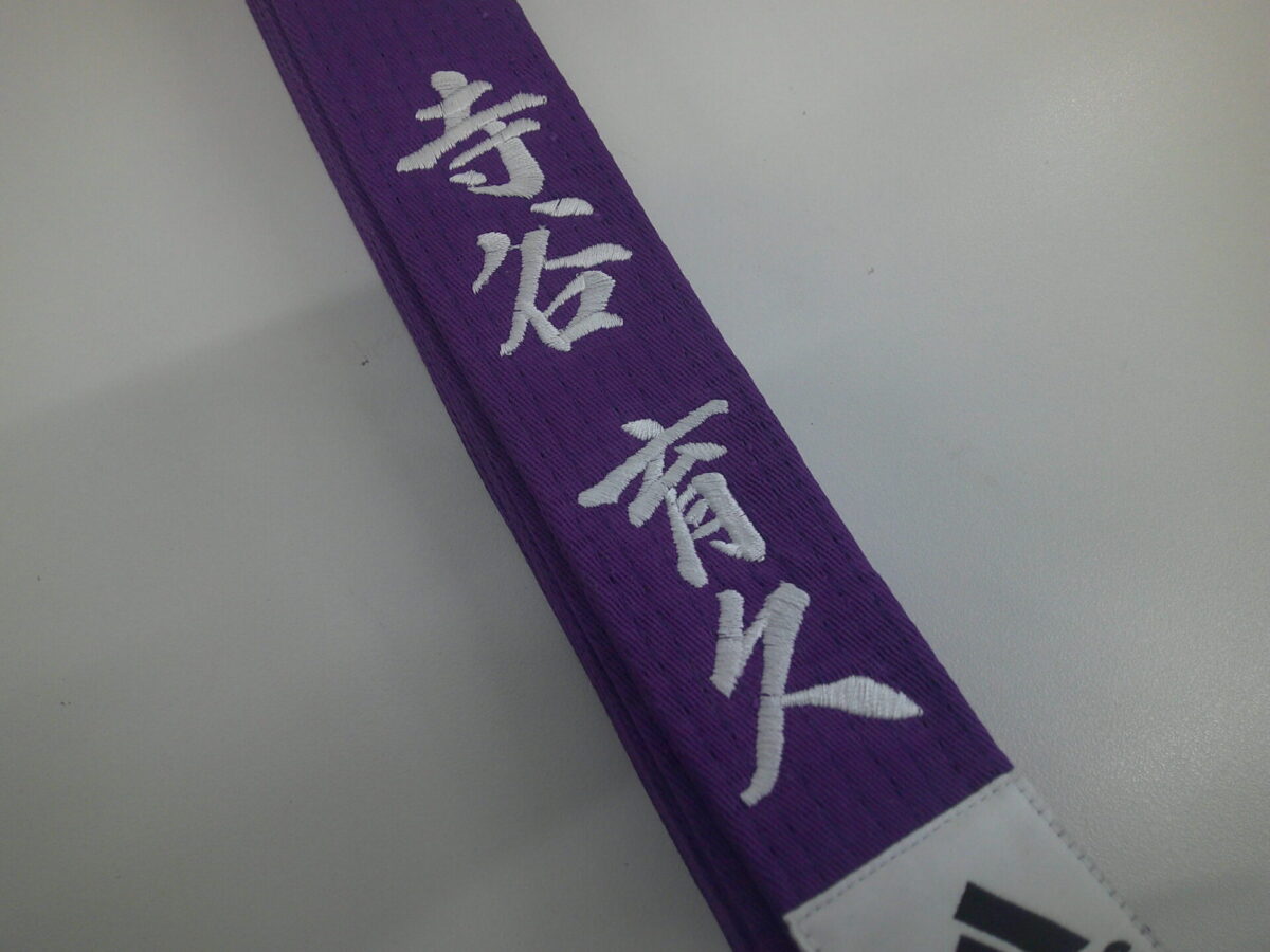 紫の空手帯に行書体(白糸)で氏名を刺繍した制作実績。