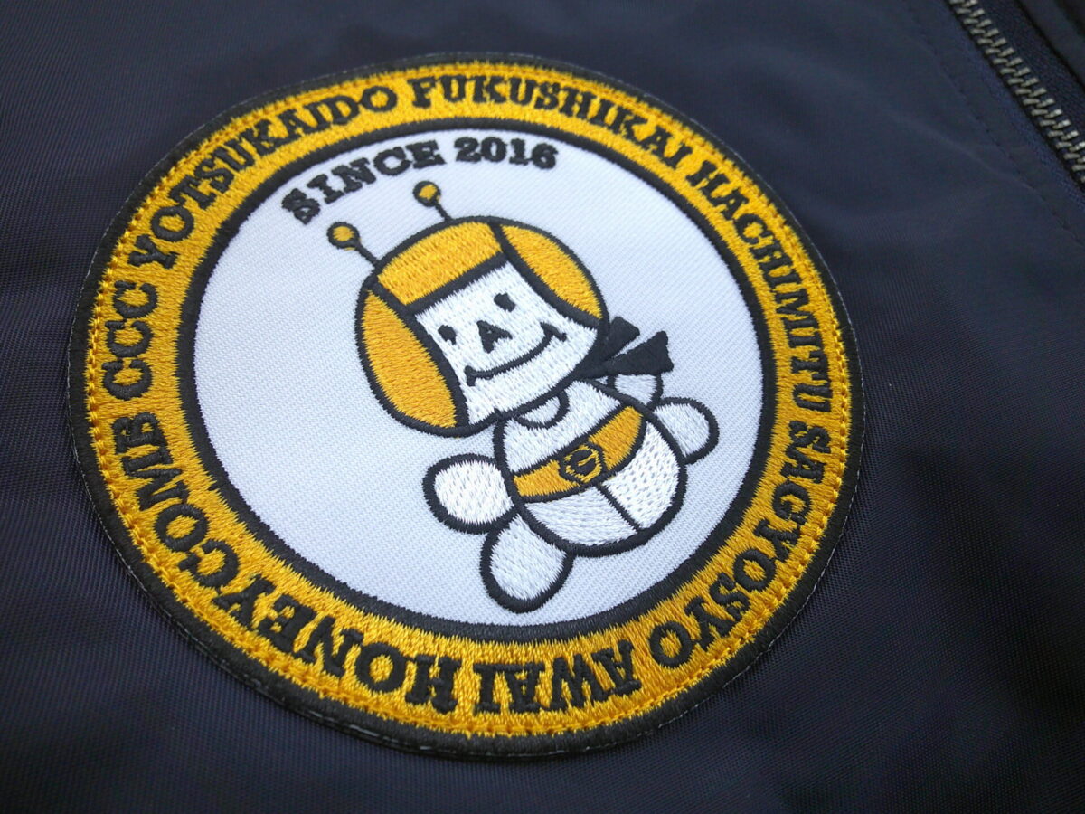 福祉施設の円形ワッペンをジャケット右胸に縫い付けた全体像。