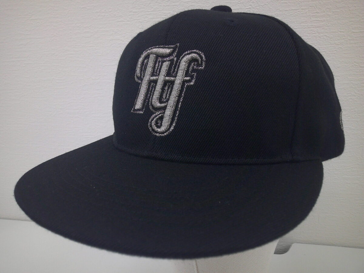 ベースボールキャップフロントにロゴ文字を3D刺繍。刺繍糸は銀の蛇腹糸を使用