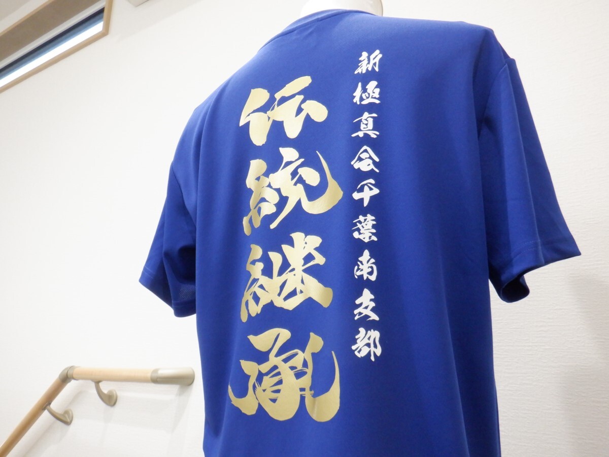 青いTシャツの背中にビッグサイズで白とゴールドのラバープリントを加工した制作実績。