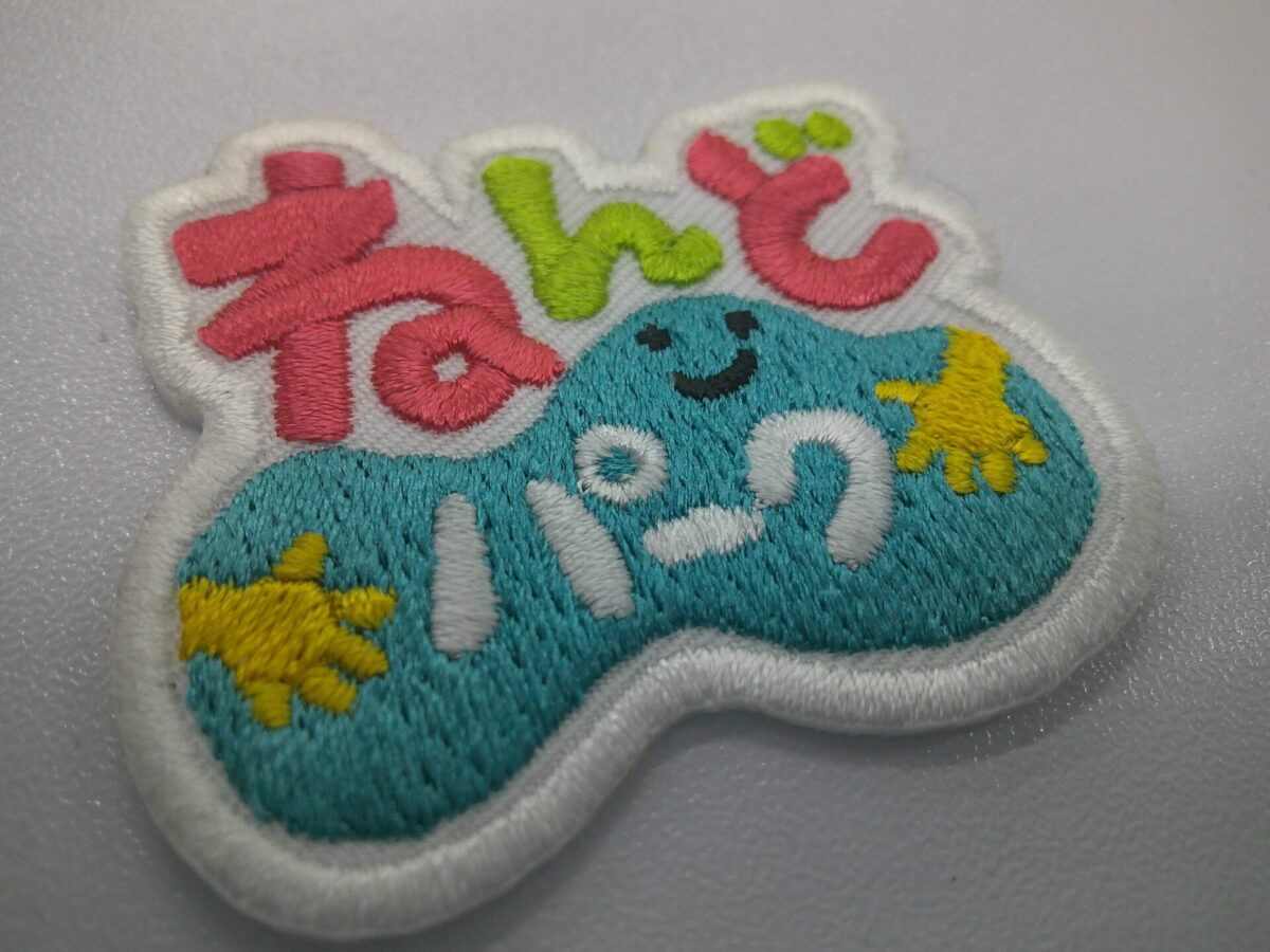 体験型施設のオリジナルロゴ刺繍ワッペン。ピンク・ライム・ターコイズ・山吹色の可愛らしく、優しい雰囲気の制作事例。
