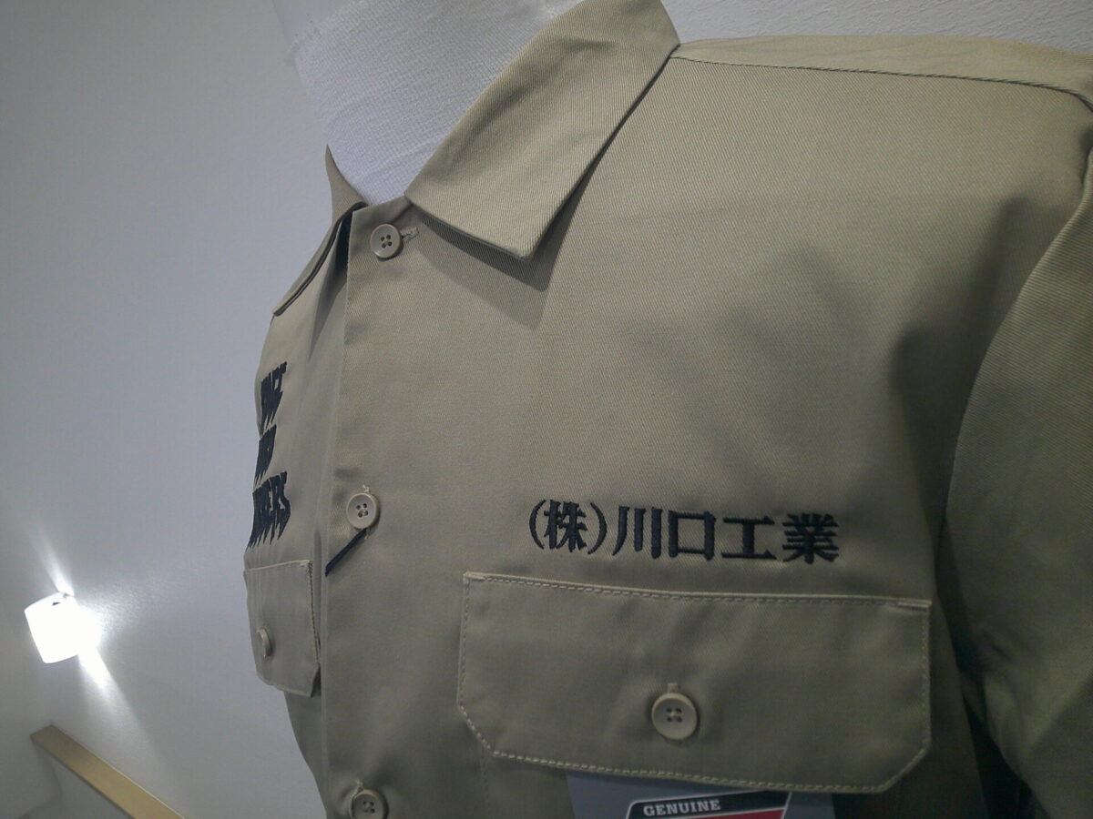 ブラウンのワークジャケットに黒糸で会社名を刺繍した制作事例。書体は明朝体を使用。