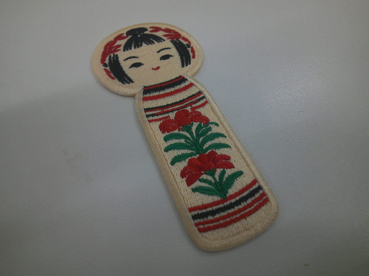 可愛らしいこけしのデザインをオリジナル刺繍ワッペンとして製作した事例。