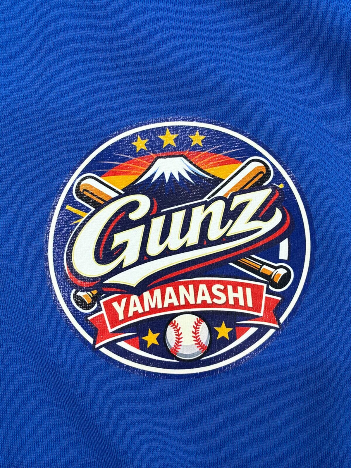 ブルーの子供用Tシャツの左胸に野球チームのロゴをエンブレムプリント加工した制作事例のアップ。