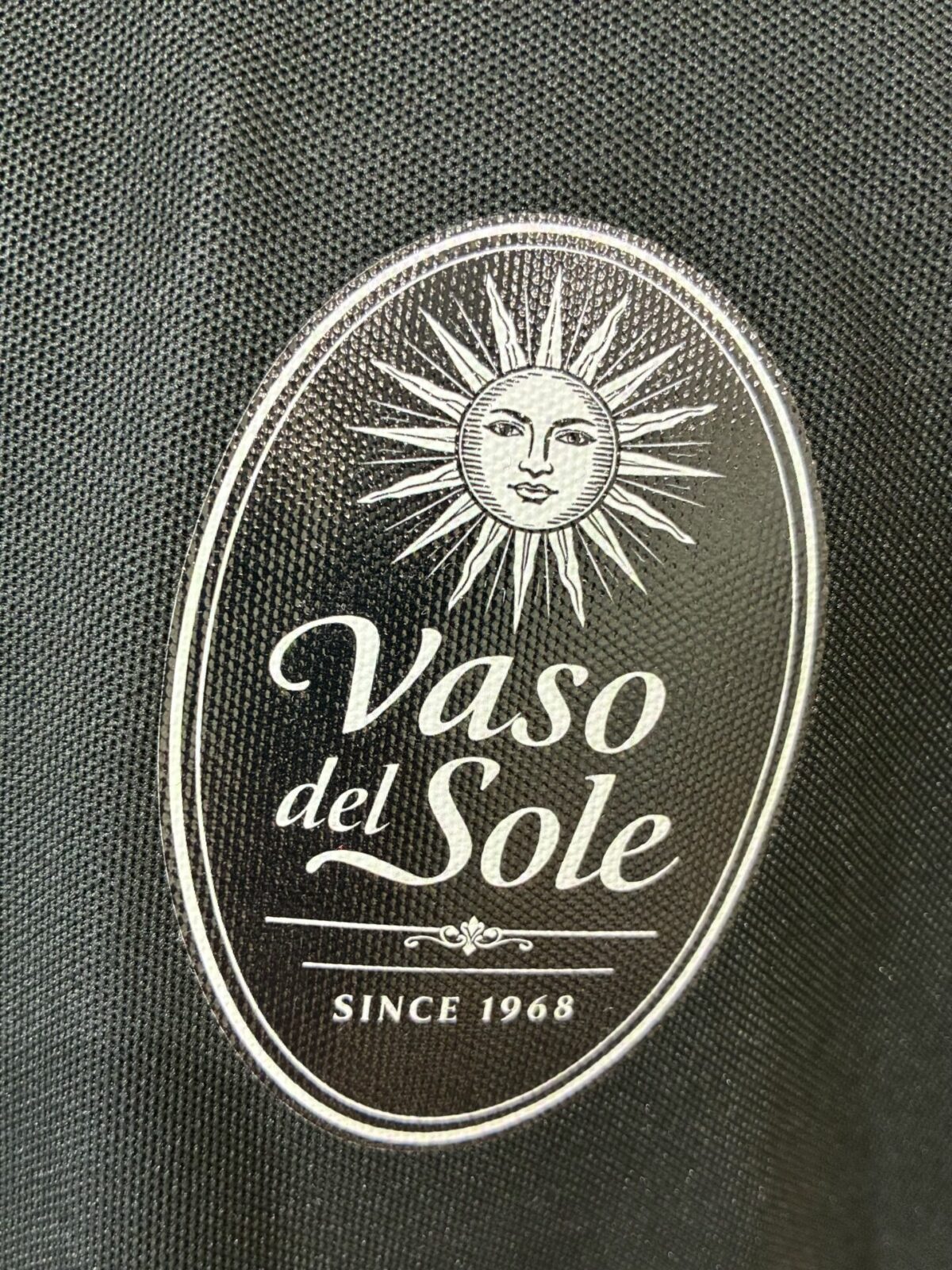 イタリア料理店のオリジナルロゴを左胸にエンブレムプリントを加工した制作事例。真上からのアップ。